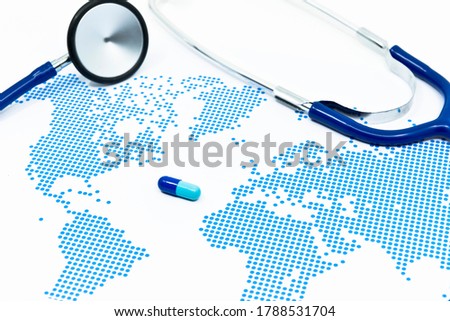 Blue capsule medicine and stethoscope on the blue dots pattern world map. Global medical examination and pandemic prevention by a novel drug.