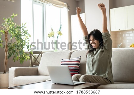 Excited indian woman celebrating online win success looking at laptop at home. Happy euphoric indian lady student, lottery winner raising hands get new job opportunity, watching game on computer. Royalty-Free Stock Photo #1788533687