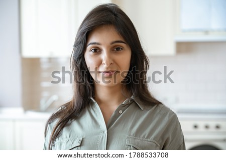 Confident young pretty indian ethnicity woman looking at camera alone at home in kitchen. Happy beautiful millennial hindu lady housewife in India indoors, close up face front headshot portrait. Royalty-Free Stock Photo #1788533708