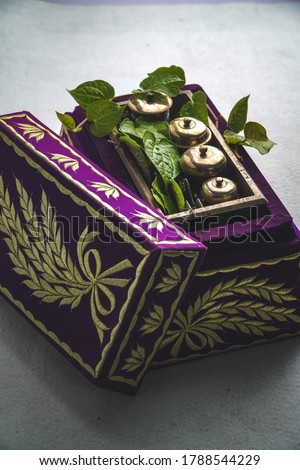 Betel leaf refers to a container made of metal to store the ingredients used in the preparation of leaves from betel tree for eating. Royalty-Free Stock Photo #1788544229