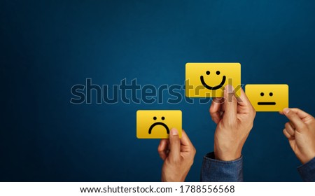 Hand of client show a feedback with smile face card. Service rating, satisfaction concept