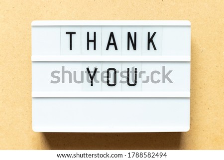 Lightbox with word thank you on wood background