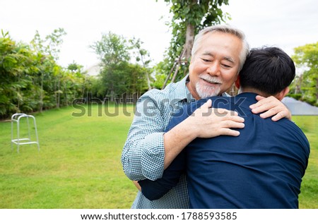 An elderly man hugged his son because he had not seen each other for a long time because he was quarantine in the epidemic situation of the Covid-19 virus. The concept of love and concern.