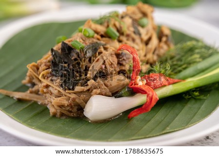 Mok bamboo shoots, put the pork on the banana leaf on a white plate. Thai food.