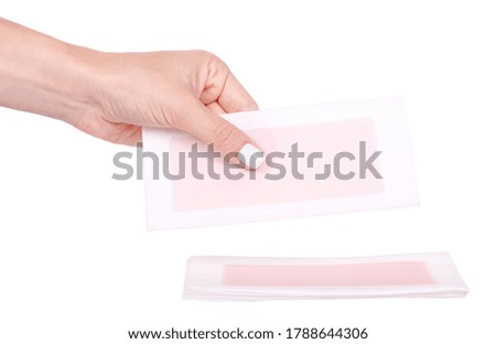 Hand with paper wax strip for hair removal, isolated on white background.