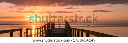 scenic sunrise with pier by the sea