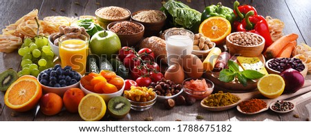 Composition with assorted organic food products on wooden kitchen table. Royalty-Free Stock Photo #1788675182