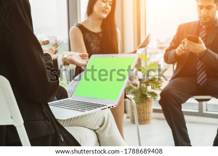 Business people in the conference room with green screen chroma key TV or computer on the office table. Diverse group of businessman and businesswoman in meeting on video conference call .