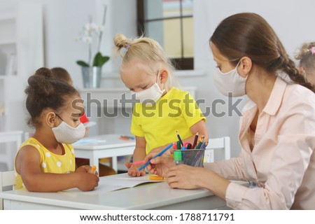 Teacher and children with face mask at school covid19 lesson after quarantine and lockdown Royalty-Free Stock Photo #1788711791