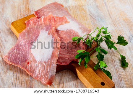 Close up of raw pork  on wooden surface with ingredients, nobody