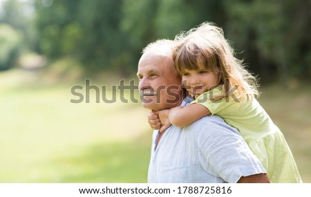 Little child girl hugs grandpa On Walk in the summer outdoors. Concept of friendly family.
 Royalty-Free Stock Photo #1788725816