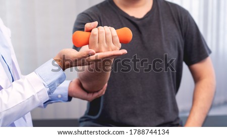 physiotherapist doctor rehabilitation consulting physiotherapy giving dumbbell exercising treatment with patient in physio clinic or hospital Royalty-Free Stock Photo #1788744134