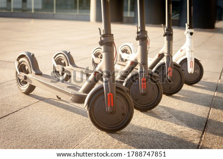 electric scooters stand on the street against the background of the city, transport of the future, eco transport rental, close-up Royalty-Free Stock Photo #1788747851