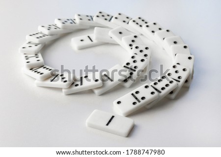 Falling white dominoes. Domino effect. Structural instability