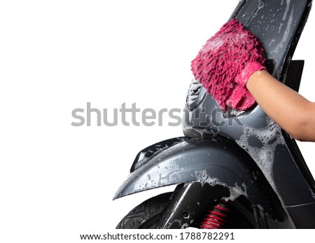 Hand washing a motorcycle or motor scooter isolated on white background