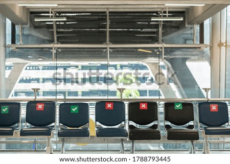 Symbol sticker on chair in international airport. New Normal and social distancing concepts, protection Coronavirus disease (Covid-19) infection