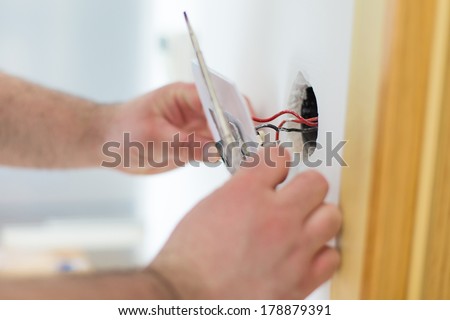 Man installing light switch after home renovation Royalty-Free Stock Photo #178879391
