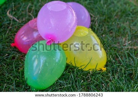 colorful water ballons in green grass - children playing ballons