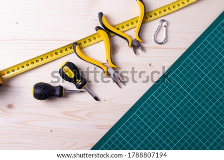 different mechanic or electrician worker tools on the green checked mat for fixing or repairing things
