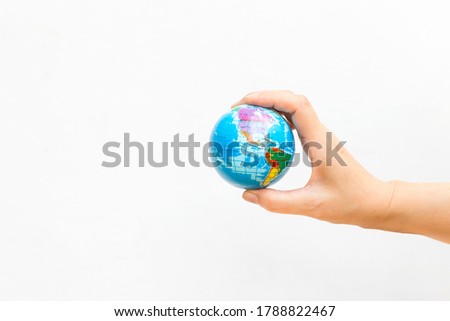 World map foam Earth Globe stress relief bouncy ball in girl hand on white background, world news or environmental