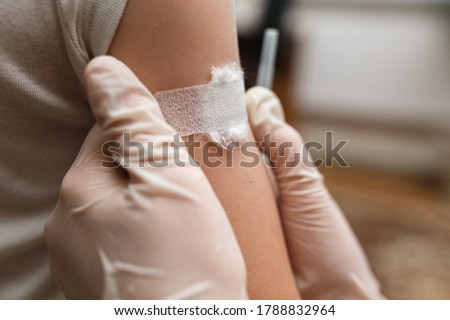 Child with a medical tape on his shoulder after a vaccination injection. Prevention of diseases in children through vaccination. Health care and medicine concept. Focus on shoulder. Royalty-Free Stock Photo #1788832964