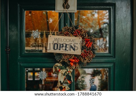 
welcome open. sign board through the glass of store window.