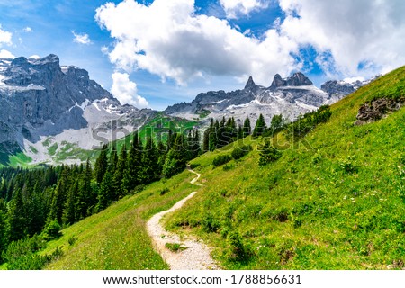 the three towers in the mountains from Vorarlberg. the mountains are in the clouds, shined by the sun. changing light conditions in the Alps. Alps of Austria. between Austria and Switzerland. Royalty-Free Stock Photo #1788856631