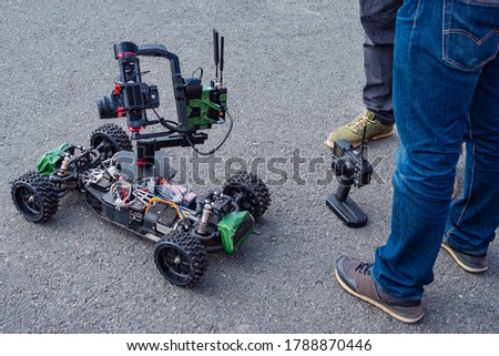 Video production. Video recording equipment. Stabilization of the shooting equipment. Remote-controlled video camera. People are standing next to the mobile shooting equipment.