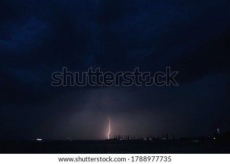 Lightning and storm clouds in the night sky over the sea