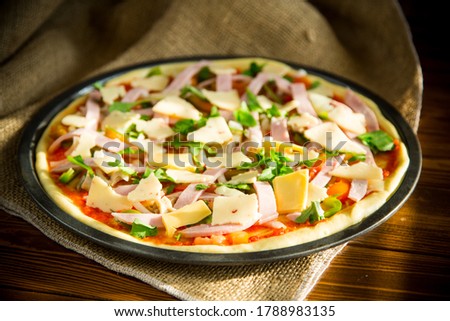 raw pizza with assorted filling in a metal form