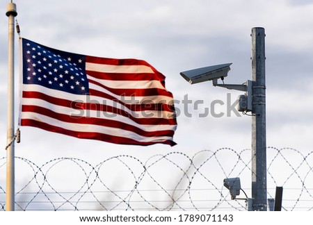 USA border, surveillance camera, barbed wire and USA flag, concept picture Royalty-Free Stock Photo #1789071143