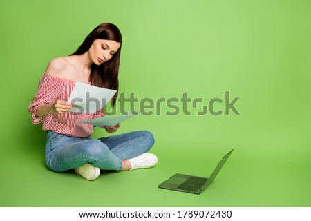 Full body size photo of charming lovely serious young girl cross legs work recent project deadline wear denim striped white red blouse uncovered shoulders bright green color background