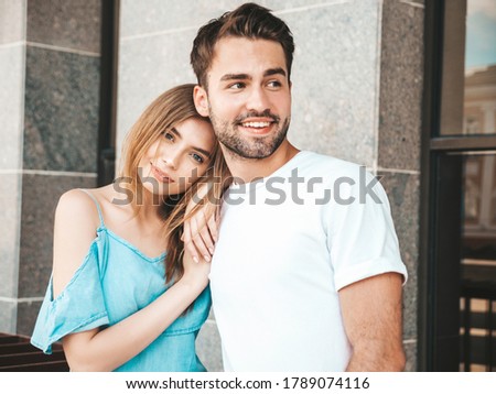 Portrait of smiling beautiful woman and her handsome boyfriend. Woman in casual summer jeans dress. Happy cheerful family. Female having fun. Couple posing on the street background