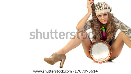 Studio shooting of the model. Cute young girl took a photo with a banjo. 
