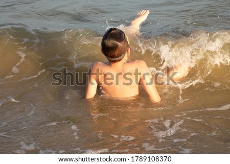 Boy 10 years old enjoys swimming in the coastal waves in the sea