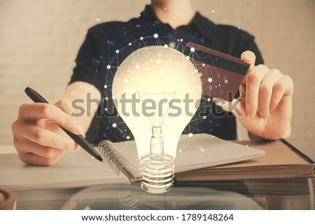 Double exposure of man hands holding a credit card and bulb drawing. Idea E-commerce concept.