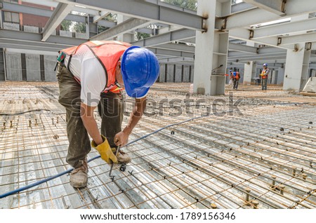 Construction worker tightening the iron mesh rods to steel plates
Galvanized steel flooring in a big construction site