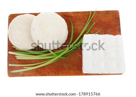 dairy food : feta white cheese cubes on cut wooden plate isolated over white background