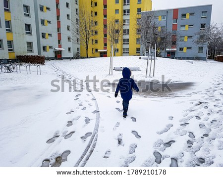 Child runs through the snow in Leherheide, Bremerhaven in Germany.