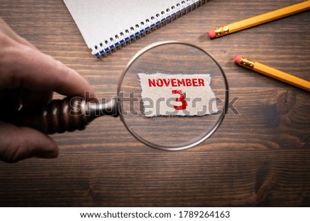 NOVEMBER 3, 2020  US election date. Man's hand, holding magnifying glass 