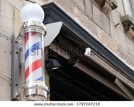 barber colored pole shop sign in vintage hairdresser wall with round white red blue colors