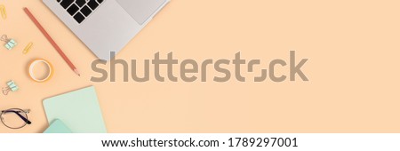 Banner with laptop, glasses and office supplies on a beige background. Workspace concept with place for text.