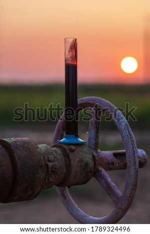 Oil sample in a test tube on an oil pump