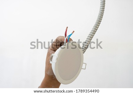 Men hands connected wires before installation of a slim led lamp in the suspended ceiling - montage of stretch ceilings close up