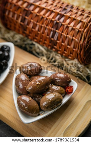 different types of olives on a dark concrete