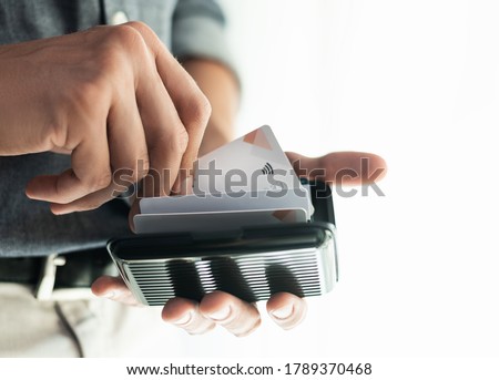 Man holding contactless credit card in a wallet with RFID protection. Selective focus
