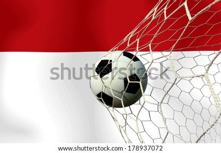 The symbolic power of success and victory. Classic soccer ball (football) has black and white color going into the in-goal net score after shot in the game.Concept success Monaco soccer ball