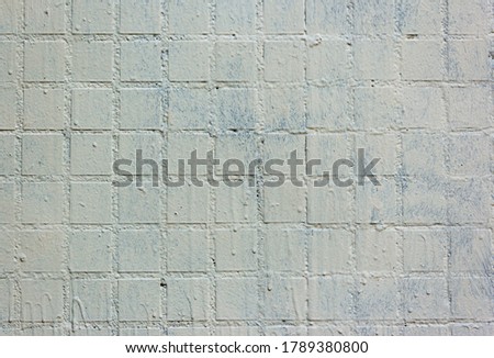 Old square background mosaic. Abstract pixels. Texture for facing the walls of the house, bathroom, kitchen, tiled floor. Rough white-painted mosaic tiles on the walls. Square mosaic tile.