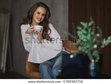 beautiful woman holding a cup of coffee in her hands and smiling