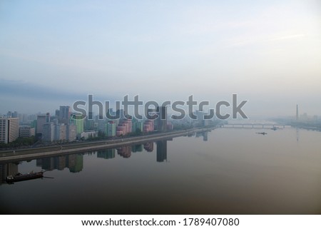 Pyongyang, North Korea. Skyline and Taedong River in the morning fog. View on modern residential complex on the Othat Kangan street from the Yanggakdo island Royalty-Free Stock Photo #1789407080